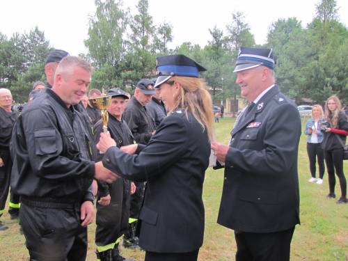 Zastępca Wójta Gminy wraz z Komendantem Gminnym OSP wręczający puchar oraz pamiątkowy dyplom dowódcy drużyny OSP Wola Mokrzeska.