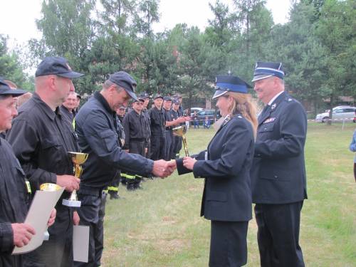Zastępca Wójta Gminy wraz z Komendantem Gminnym OSP wręczający puchar oraz pamiątkowy dyplom dowódcy drużyny OSP Przyrów.